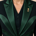 NAKHLAH upper-front detail showing branching green silk lines and the gold Saudi emblem.