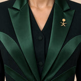 NAKHLAH upper-front detail showing branching green silk lines and the gold Saudi emblem.