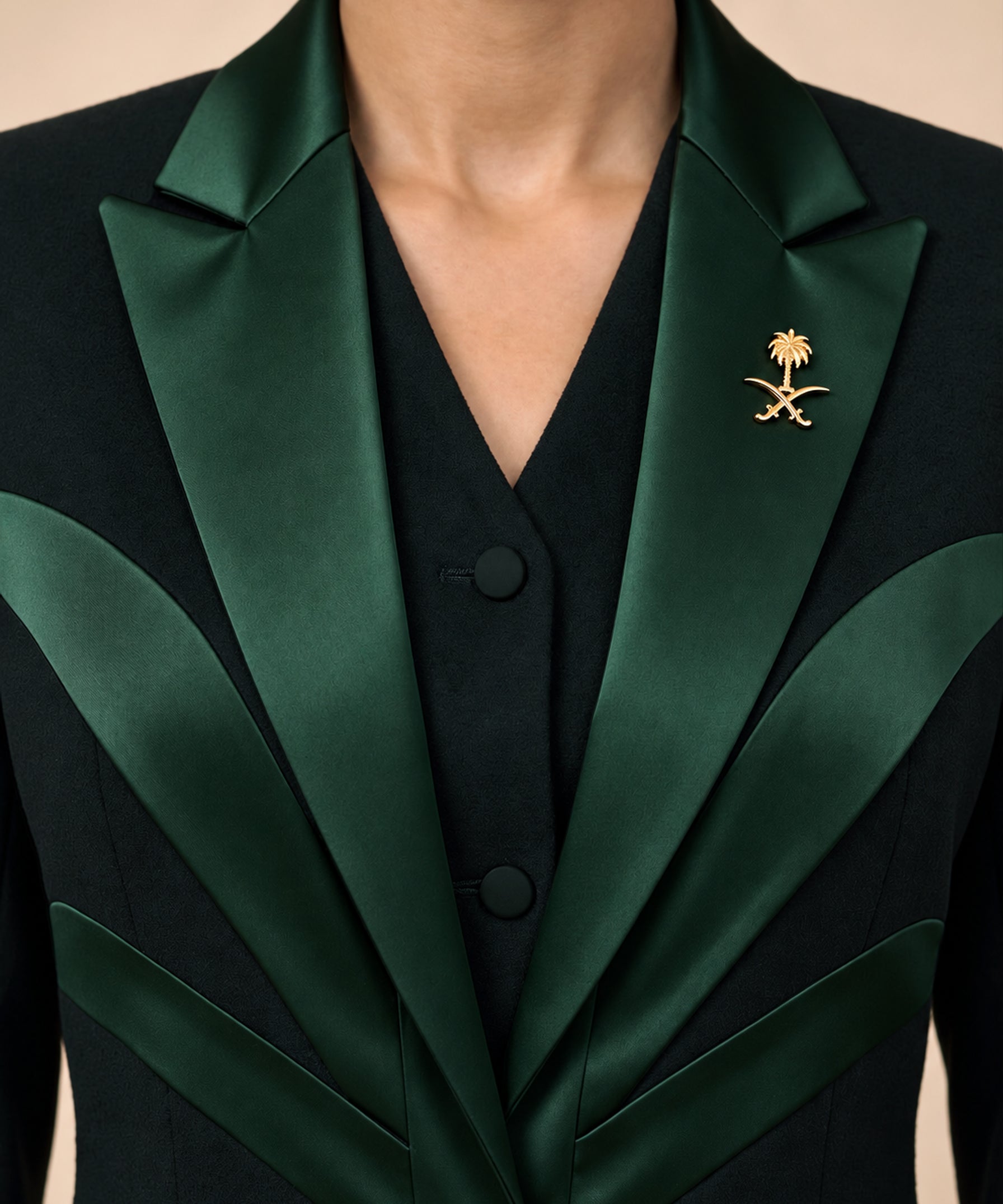 NAKHLAH upper-front detail showing branching green silk lines and the gold Saudi emblem.