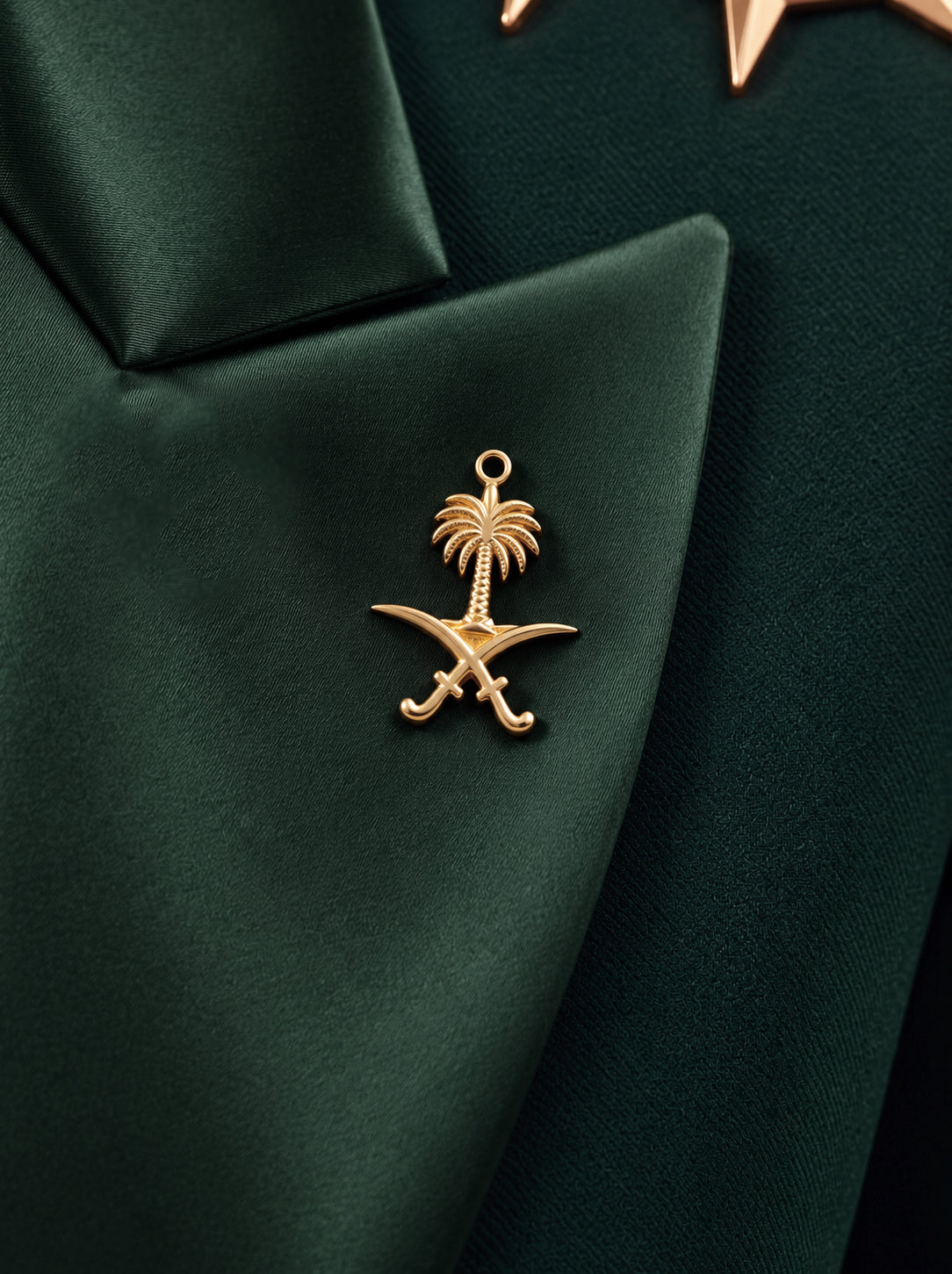 GLORY green silk lapel close-up with the gold Saudi palm-and-crossed-swords emblem.