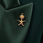 GLORY green silk lapel close-up with the gold Saudi palm-and-crossed-swords emblem.
