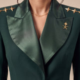 GLORY upper-front detail showing broad green silk lapels, gold stars and the Saudi emblem.