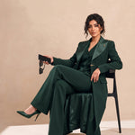 GLORY long blazer styled with a coordinating vest and trousers in a seated editorial pose.