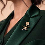 NAKHLAH lapel close-up with the gold Saudi palm-and-crossed-swords emblem.
