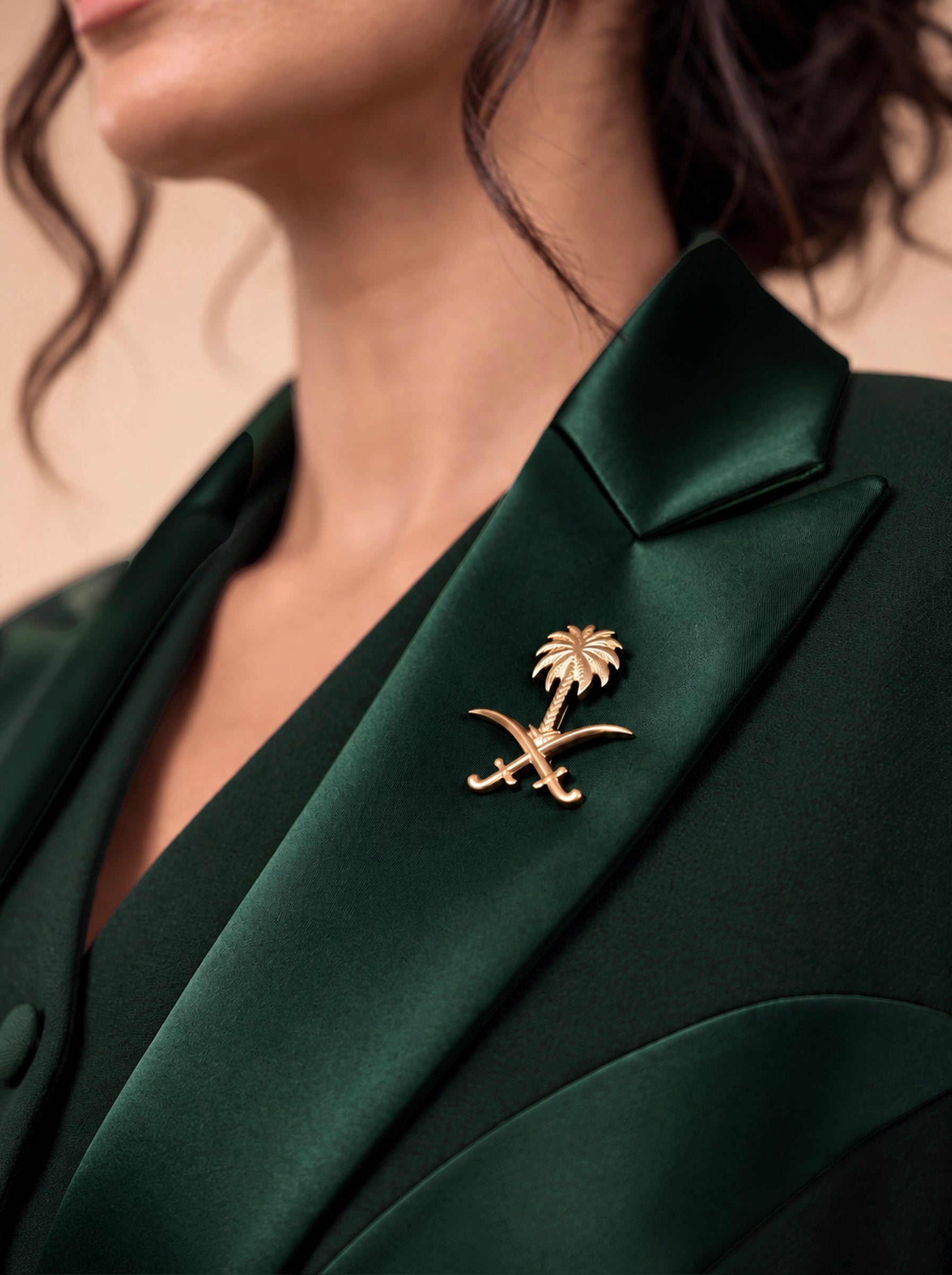 NAKHLAH lapel close-up with the gold Saudi palm-and-crossed-swords emblem.