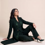 TERRA long blazer styled open with a coordinating vest and trousers in a seated editorial pose.