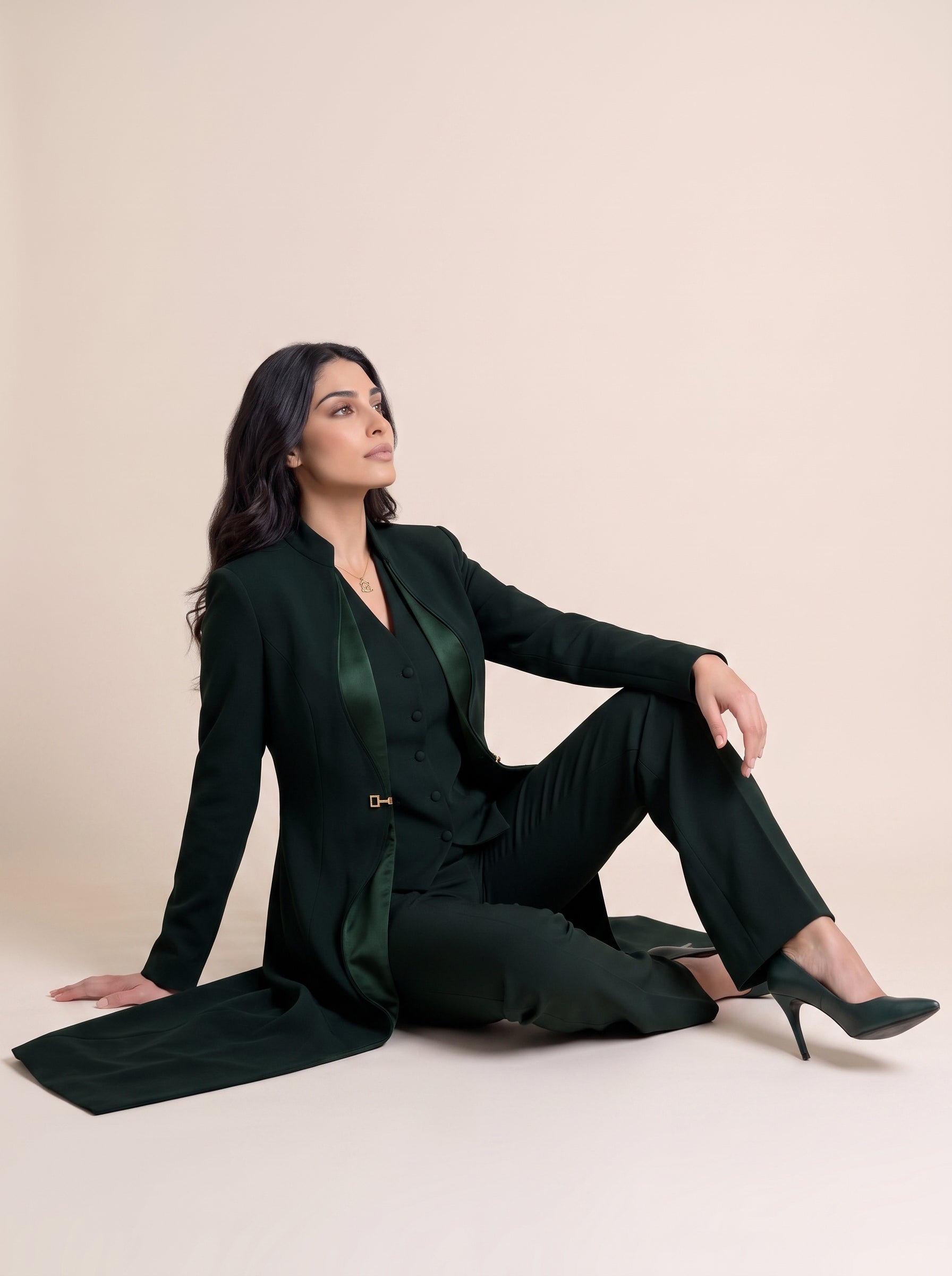 TERRA long blazer styled open with a coordinating vest and trousers in a seated editorial pose.