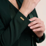TERRA sleeve cuff detail with gold-tone VEORA nameplate.