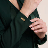 TERRA sleeve cuff detail with gold-tone VEORA nameplate.